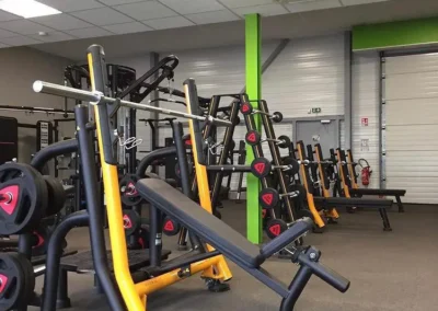 Espace musculation libre du club Fitaccess Saint-Marcel-lès-Valence avec bancs, racks et poids libres.
