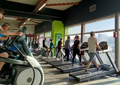 Adhérents s'entraînant sur des tapis de course dans l'espace cardio training d'une salle de sport Fitaccess en Auvergne-Rhône-Alpes
