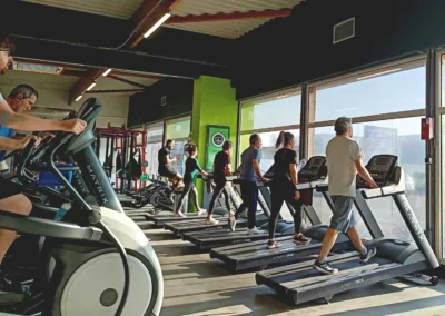 Adhérents s'entraînant sur des tapis de course dans l'espace cardio training d'une salle de sport Fitaccess en Auvergne-Rhône-Alpes