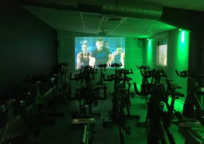 Studio RPM du club Fitaccess Saint-Marcel-lès-Valence avec vélos indoor et cours diffusé sur écran.